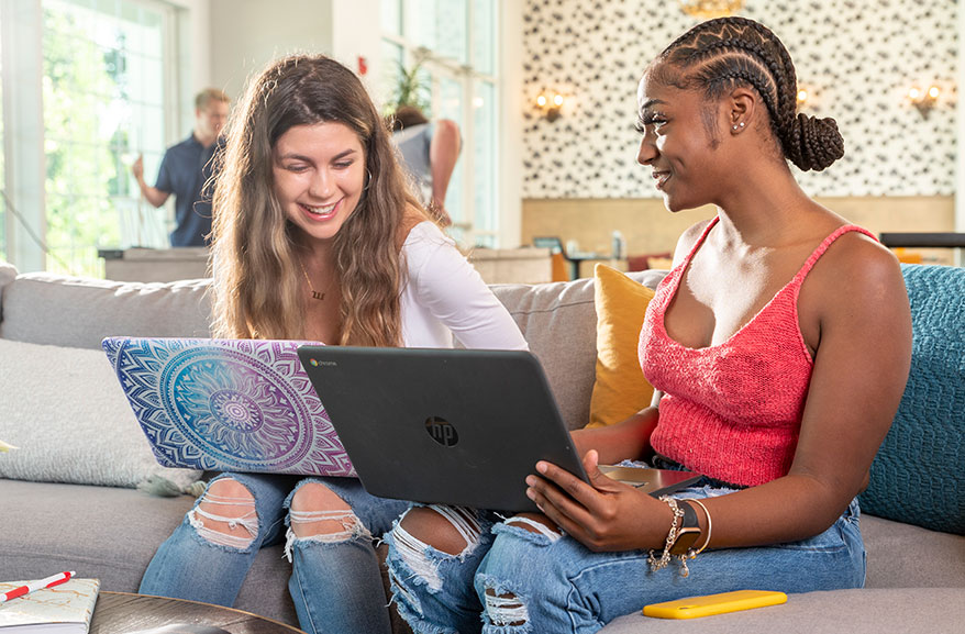 Young young woman having a conversation while using their laptop computers